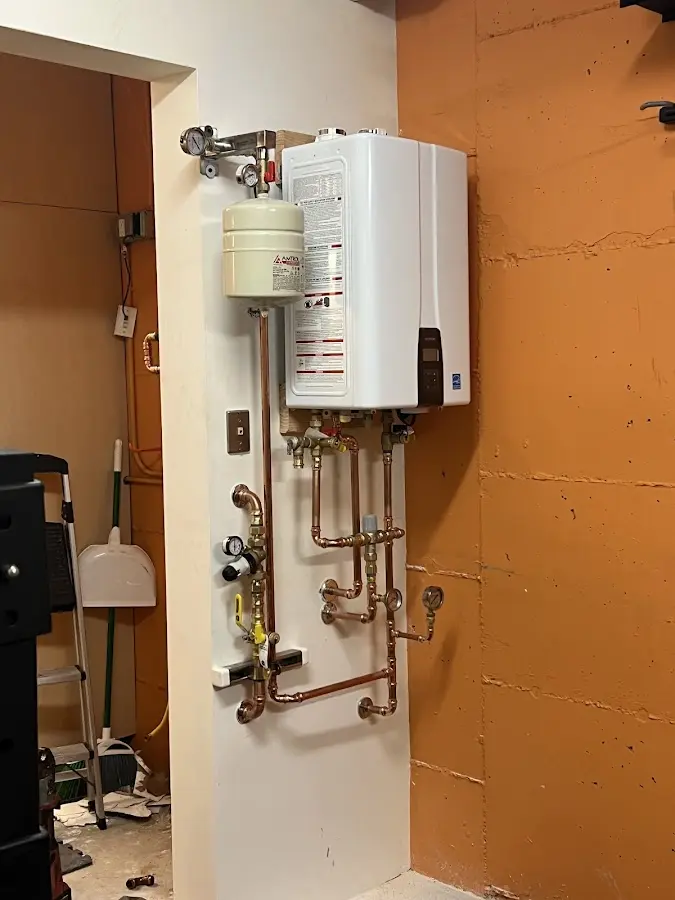 Plumbing technician inspecting water heater connections in Hoschton